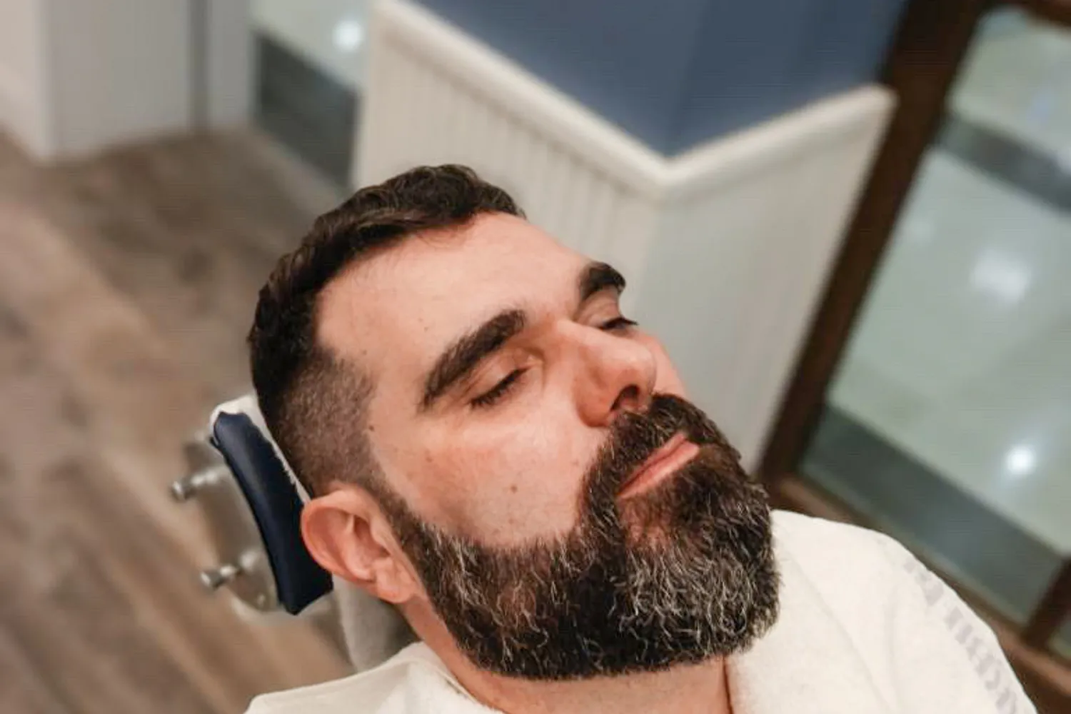 Uomo con barba scura rilassato in poltrona