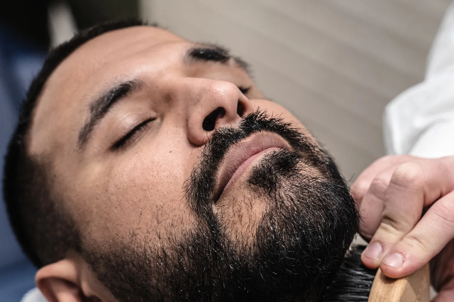 Barbiere che spazzola la barba di un cliente